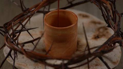 Cup filled with wine surrounded by Jesus crown of thorns and Bread. Christian Stock Footage