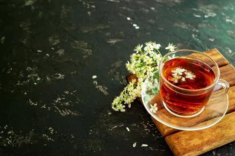 A cup of flower tea with spring cherry blossom on a black background. Copy sp Stock Photos
