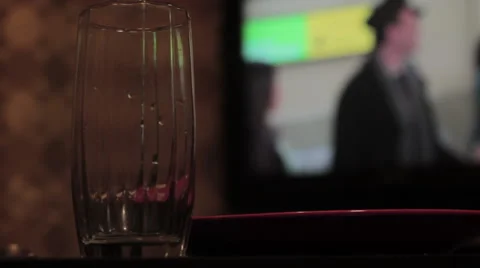 Cup in foreground, TV background Stock Footage 40484942