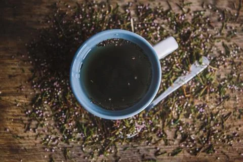Cup with fragrant, flowered black tea on a wooden background. Breakfast, heal Stock Photos