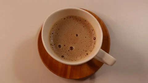 A cup of fresh aromatic coffee with foam in a white mug, top view Stock Footage 295361033