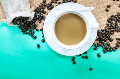 Cup of fresh coffee with coffee beans on burlap warm cup on brown background  Foto stock