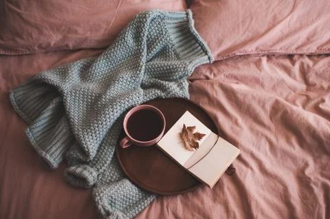 Cup of fresh coffee or tea with open sketch book with fallen autumn leaf on w Stock Photos