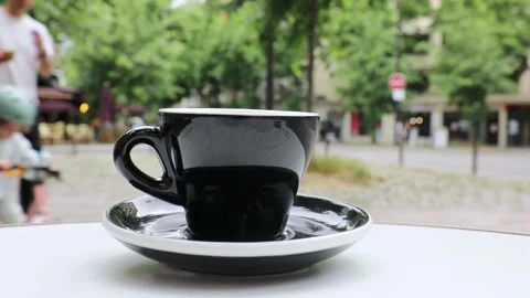 Cup of fresh hot coffee on the table of an outdoor cafe in Paris, France. Stock Footage 316601795