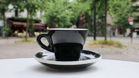 Cup of fresh hot coffee on the table of an outdoor cafe in Paris, France. Stock Footage 316601818