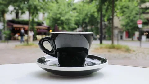 Cup of fresh hot coffee on the table of an outdoor cafe in Paris, France. Stock Footage 316601821