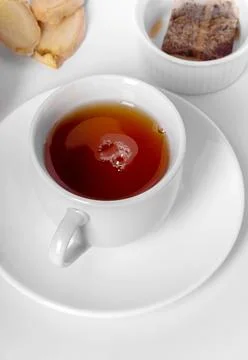 A cup of fresh tea with lemon, ginger, and tea bag. White background, isola.. Stock Photos