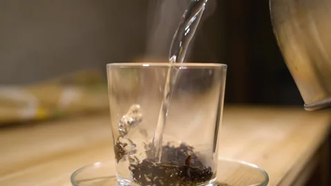 Cup of Freshly Brewed Black Tea on Wooden Table, Escaping Steam, Warm Soft Li Stock Footage 140862325