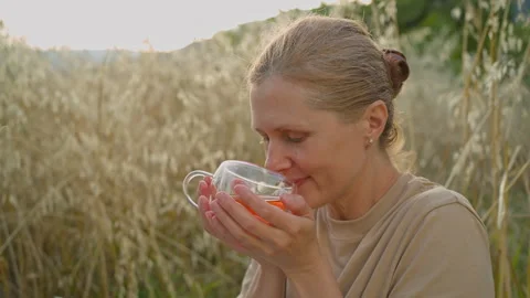 A cup of freshly brewed tea in the hands of a woman at a picnic. Stock Footage 278119118