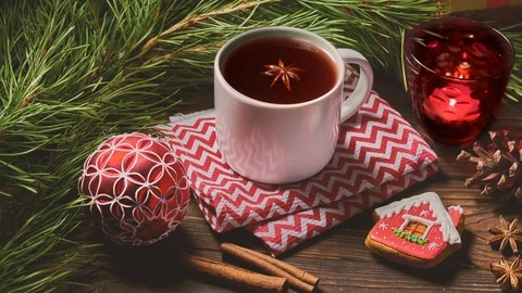 Cup of fruit tea and Christmas decorations on wooden table with fir tree Stock Footage 122687934