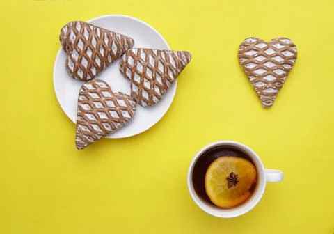 Cup of fruit tea with anise and lemon and glazed gingerbread cookies Stock Photos