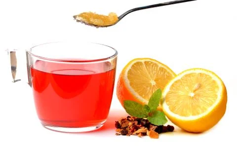 Cup of fruit tea, half pieced lemon, heap of dried tea and teaspoon of honey Stock Photos