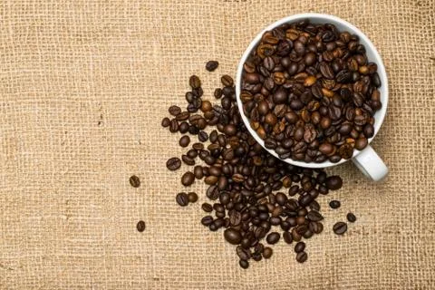Cup full of coffee beans over cloth background Fotos de archivo
