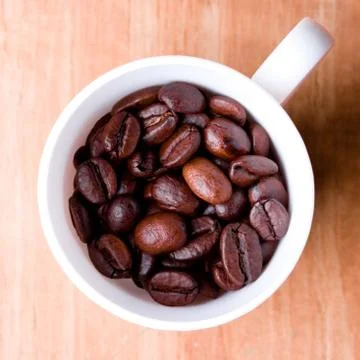 Cup full of coffee beans Stockfoto's