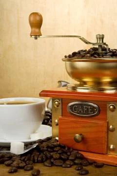 Cup full of coffee, beans, pot and grinder Stock Photos