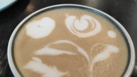 A cup of ginger coffee with flower latte art Stock Footage 264953158