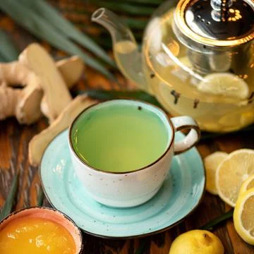 Cup of ginger-lemon tea, close-up shot. Vitamin drink with honey useful for Stock Photos