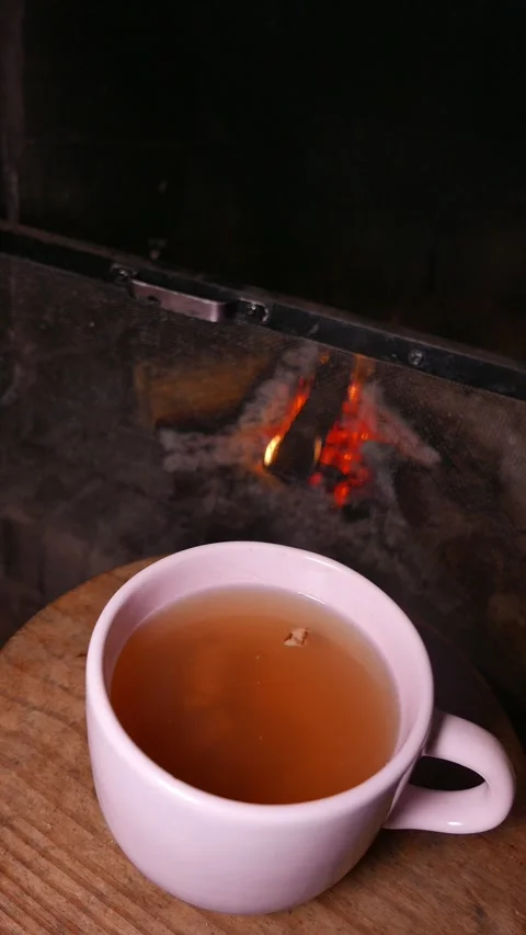 A cup of ginger tea with honey.  Pieces of ginger swirl inside the cup. A teacup Stock Footage 342894782