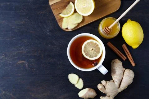 Cup of ginger tea with lemon and honey on dark background. Top view. Antiviral Fotos de archivo