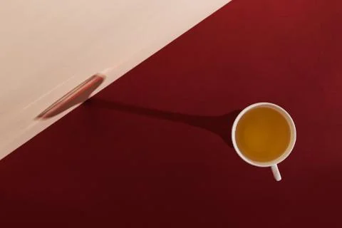 A cup of green tea casts the shadow of a glass of wine. The concept of waitin Stock Photos