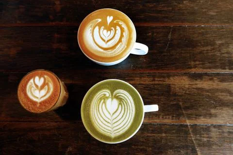 A cup of green tea matcha latte and cup of latte art coffee Stock Photos