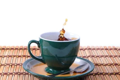 Cup of green tea with splash Stock Photos