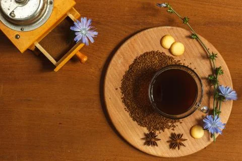 A Cup of ground chicory root coffee on a wooden stand decorated with chicory Stock Photos