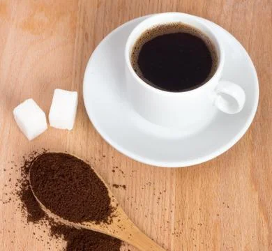 Cup of ground coffee in a spoon on the table Stock Photos