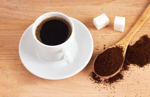 Cup of ground coffee in a spoon on the table Stock Photos