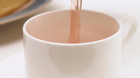 Cup of herbal tea close up on white background. Pouring hot drink into a cup Stock Footage 129200434