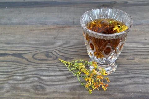 Cup of herbal tea from Hypericum: tincture or decoction of St Jonh`s wort gra Stock Photos