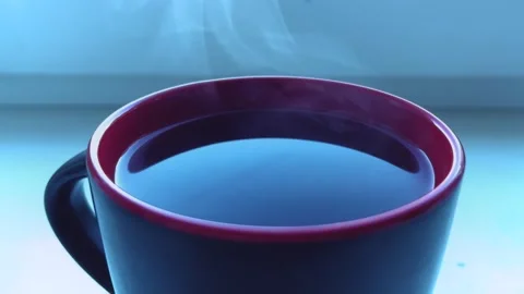 A cup of hot aromatic tea on the window.Tea is poured into a glass tea cup Stock Footage 254068246