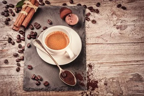 Cup of hot black coffee in setting with roasted coffee beans Photos