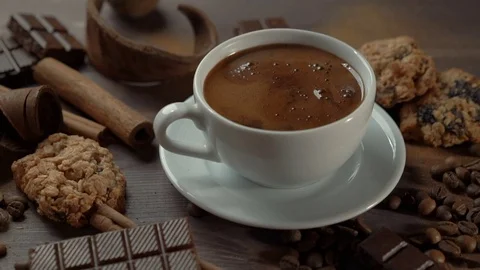 Cup of hot chocolate with cinnamon sticks, chocolate slices and cookies on old Stock Footage 82189690