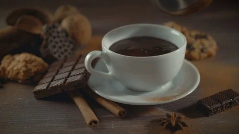 Cup of hot chocolate, cinnamon sticks, cookies and chocolate on wooden table Stock Footage 82296801