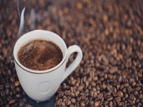 Cup with hot coffee on roasted coffee beans. Slow motion Stock Footage 73668890
