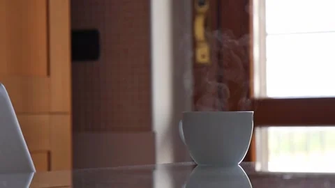 Cup of hot coffee stands on the kitchen table in the early morning. Stock Footage 255234539