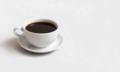 Cup of hot coffee on a white concrete background. Black coffee in a small cup Stock Photos