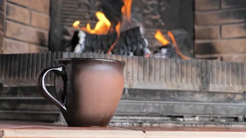 Cup of hot drink in mug front of warm fireplace. Cozy relaxed magical atmosphere Stock Footage 166892896