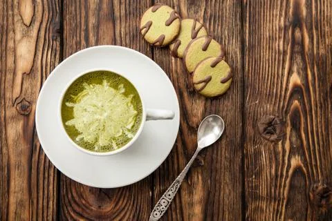 Cup of hot matcha green tea latte and green cookies on wood background Stock Photos
