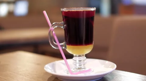 A cup of hot mulled wine on a table with pink straw Stock Footage 68030793