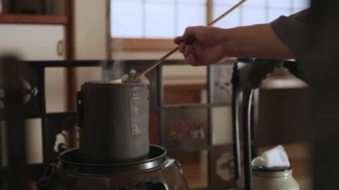 Cup of hot, steaming water being poured by tea master into a bowl in a tradition Stock Footage 199460573