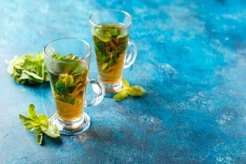 Cup of hot tea cane sugar dry tea leaves and mint herb. Stock Photos