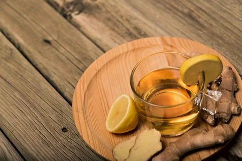 Cup of hot tea with ginger root, lemon and curcuma. Adding natural raw honey to Stockfoto's
