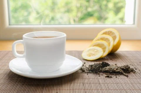 Cup of hot tea with lemon Stock Photos