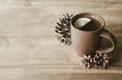 A cup of hot tea with lemon on a rustic table. Stock Photos