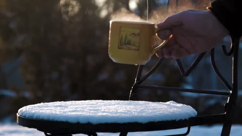Cup with hot tea on a snow covered chair Stock Footage 100537245