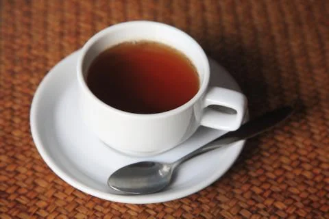 Cup of hot tea on weave table Stock Photos