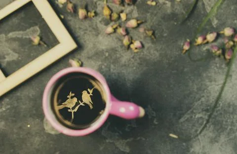 A cup of hot tea, on which is projected an bird image Stock Photos