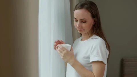 A cup of hot tea will calm the soul. An unhappy young woman drinking tea and Stock Footage 252751113